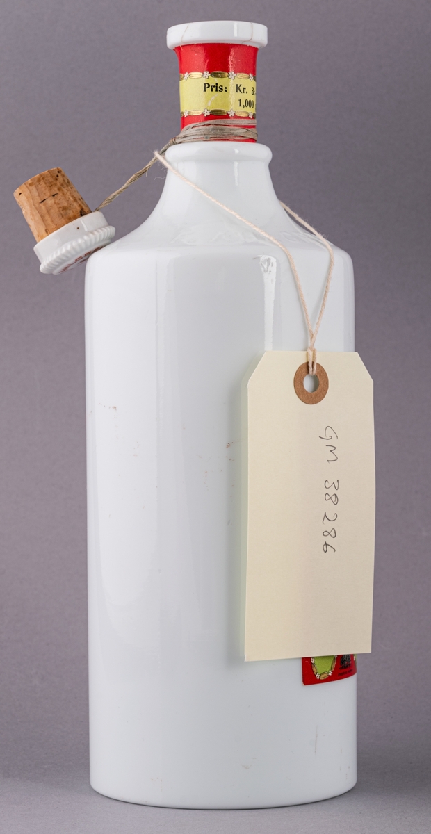 Glasflaska för munvatten, vit, med kork.  Etiketter på fram- och baksida.