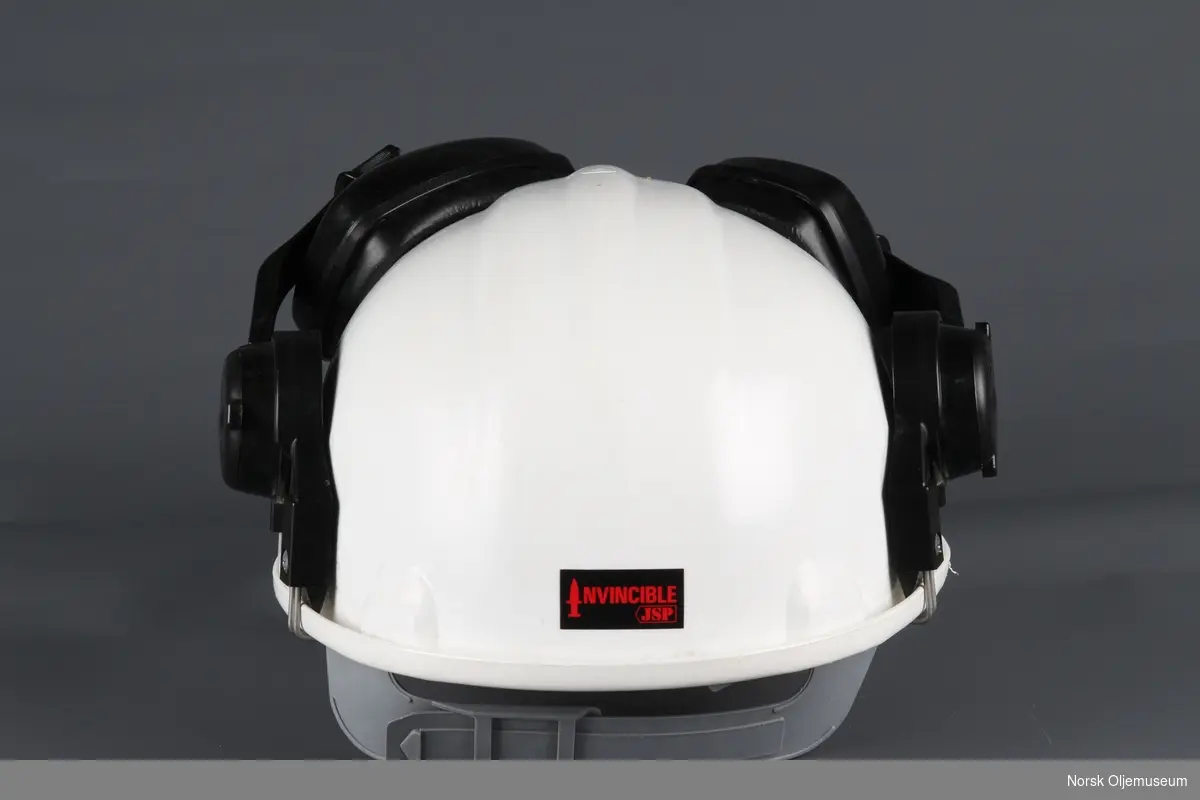 Vernehjelm med påmontert hørselsvern. Hjelmen har et klistremerke med Norwegian Contractors sin logo foran.