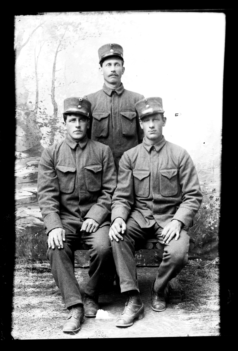 Atelierfoto.Tre soldater, to sitter og den tredje står. står.