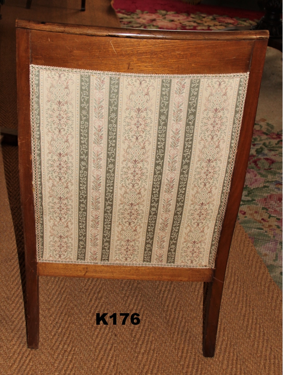Samme stol som K175, men en del detaljer er forskjellige: Lenet har en profil tvers over nesten i forkant. Lenets tverrsnitt er litt mindre flattrykt, og benene ender på et liggende ovalt stykke. Høyere lener. Venstre bakben er nytt.
Sees også på AAM E 1339.