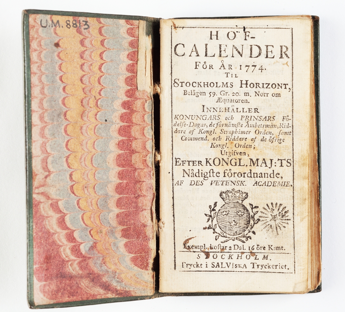 En almanack. Hofcalender för år 1774. Bunden i grått skinnband med guldtryck i form av inramade rankor. Tryckt i Salviska Tryckeriet, Stockholm.