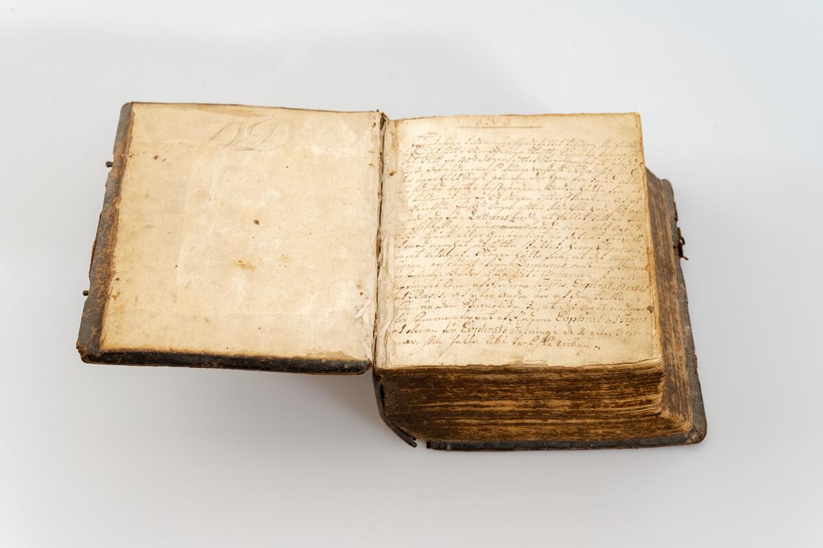 Fredrik I's bibel, publicerad 1729, med handskrivna noteringar i uppslaget. Helt skinnband med blindpressad rygg, knäppning med rikt ornerade mässingsbeslag.
