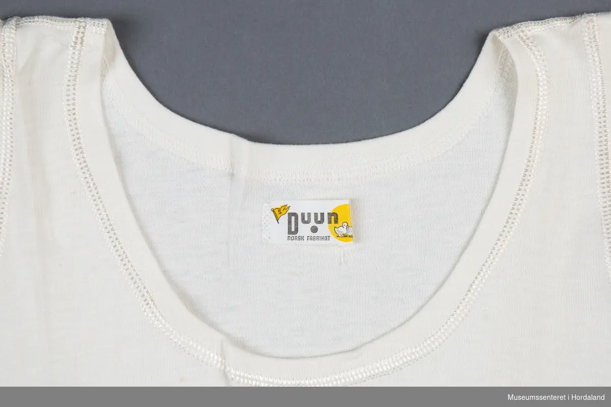 Naturfarga Duun trøye uten erm, "singlet", undertøy i str. 52. Duun-logo med ender i halsen og raudt Janus-klistermerke på baksida.