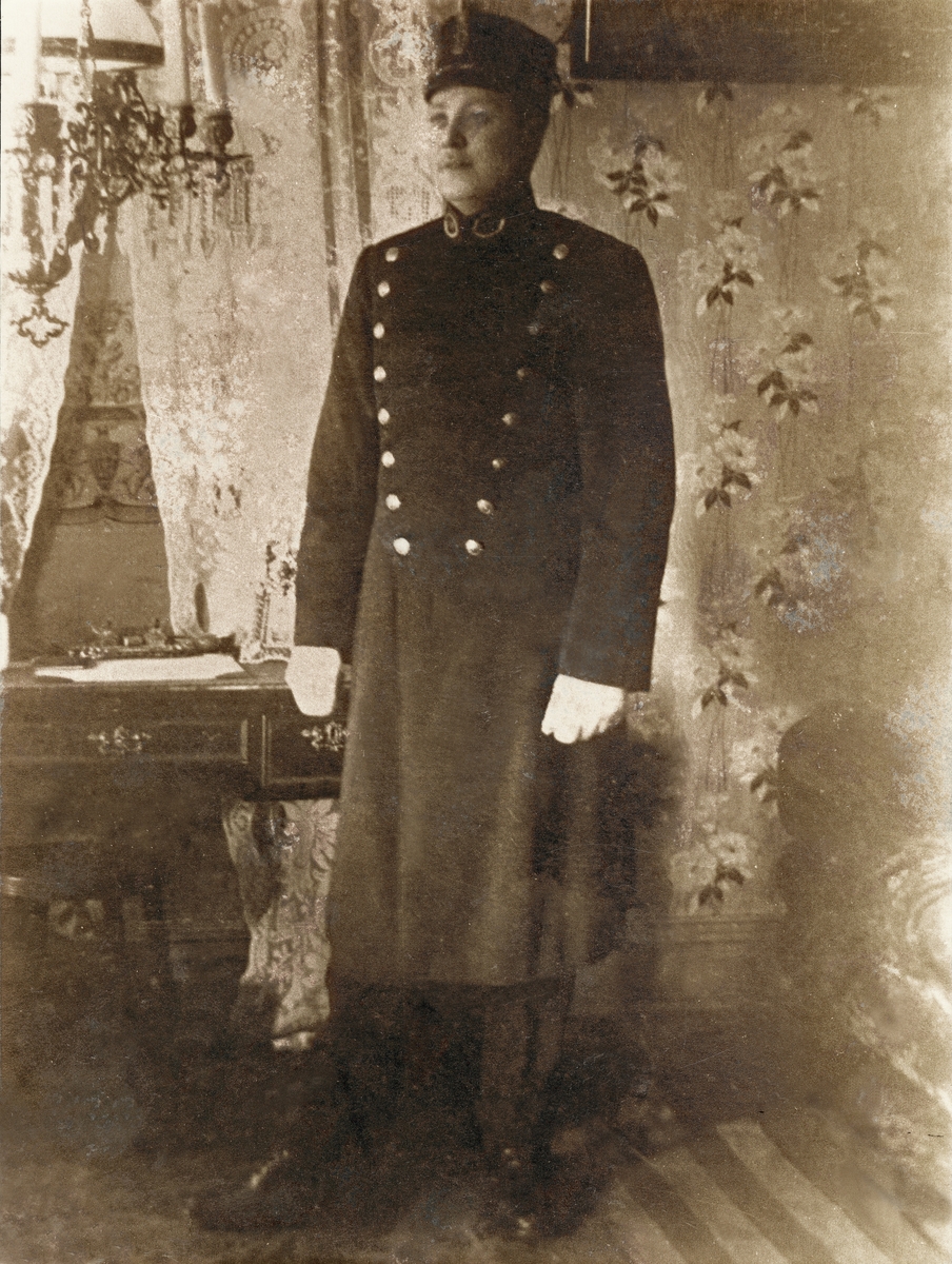 Poliskonstapel Walfrid Gyllensten poserar i ett vardagsrum.
Växjö ca 1917.