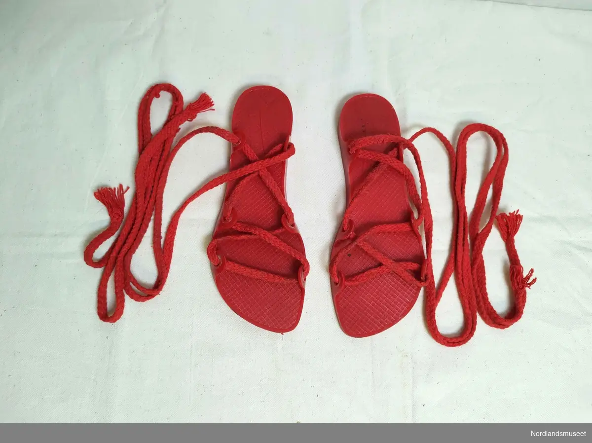 Røde sandaler til kvinne bestående av gummisåle og brede lisser som festes til denne. Str. 39.