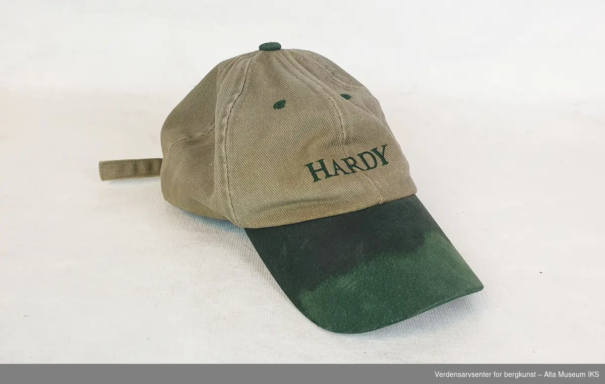 Caps i beige tøy med grønn skygge og knapp, av merket Hardy.