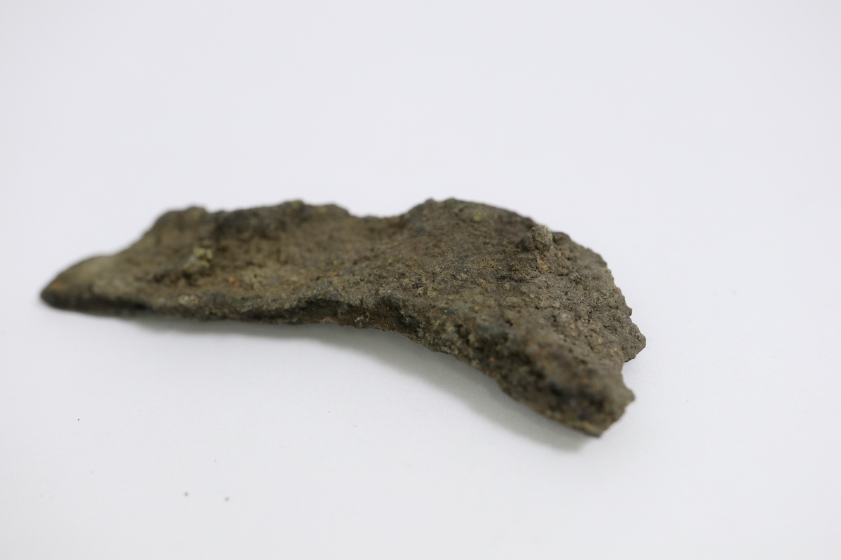Brandskadat fragment av bronsgryta.  Bukbit.