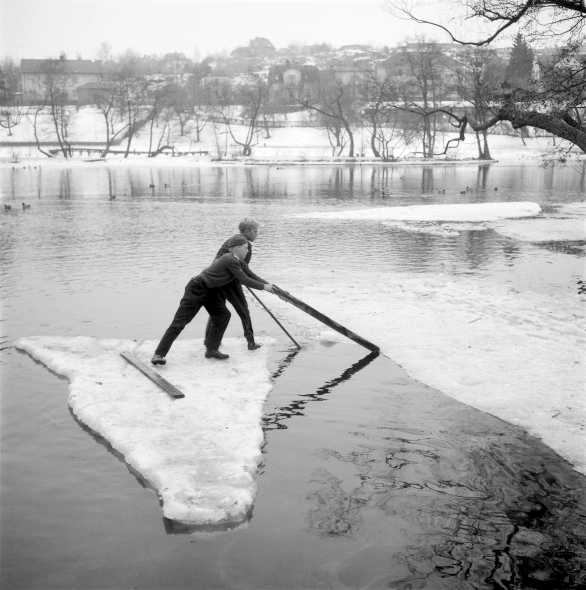 Grabbar jumpar på Stångån. En lika omtyckt som farlig lek bland stadens gossar var att isjumpa. Bilden togs från östra strandpromenaden omkring 1950. I bakgrunden ses del av Hejdegården.