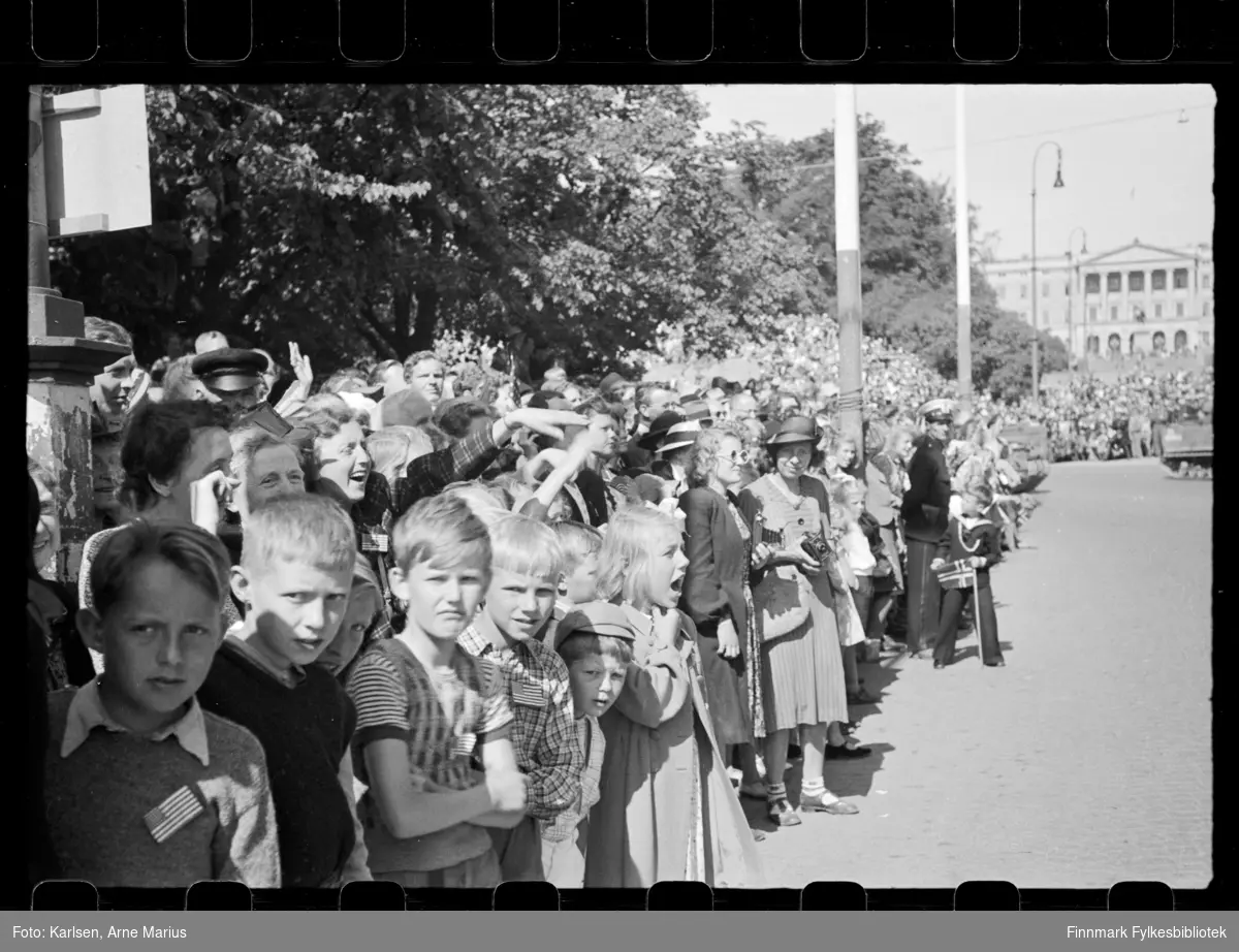Foto av tilskuere som har møtt opp for å se på militærparaden på de alliertes dag den 30. juni 1945 (The Allied Forces day) i Oslo

Amerikanske og britiske soldater deltok på paraden som marsjerte opp Karl Johansgate mot slottet (synes i bakgrunnen)