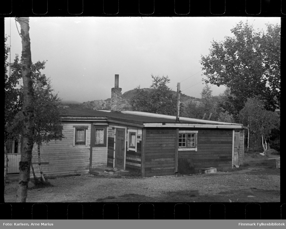 Foto av ukjent hus, antagelig i Finnmark

På veggen av huset kan man se et skilt der det står: Pengelotteriets Kommisjonær (synes bedre på foto Fbib.93112-436)

Foto trolig tatt på slutten av 1940-tallet, tidlig 1950-tallet