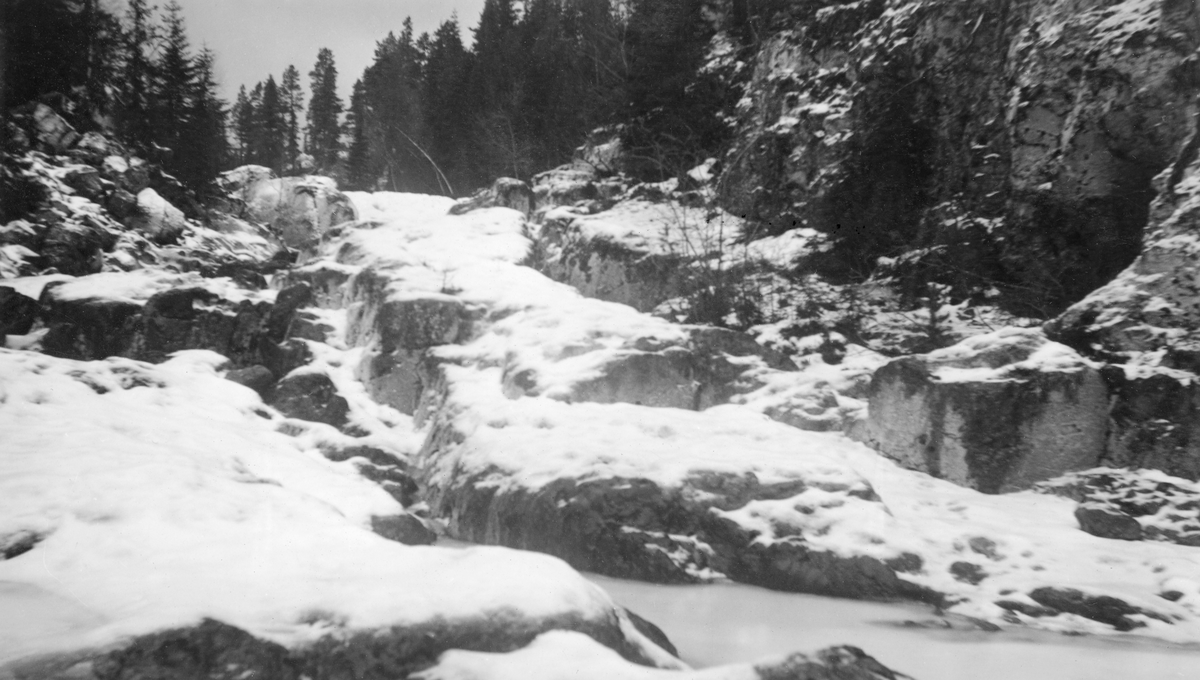 Kvitkalen, en foss i den øvre delen av elva Imsa i Stor-Elvdal kommune i Hedmark, ikke langt fra kommunegrensa mot Ringebu i Oppland. Her renner elva gjennom ei forholdsvis trang og bratt kløft i berget sommerstid. Da dette fotografiet ble tatt; antakelig tidlig på våren eller seint på høsten i 1939, var kløfta tilsynelatende fylt av is.