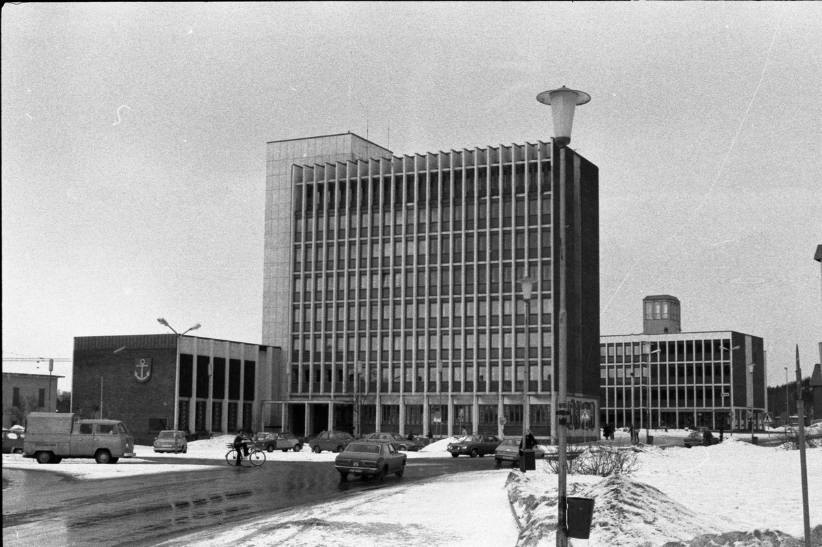 Narvik Rådhus og E-verksbygget. Slangetårnet på Brannstasjonen i bakgrunnen.Rådhuset i Narvik har en monumental form og en framtredende plassering ved torget, midt i byen. De sentrale delene av Narvik ble ødelagt under andre verdenskrig og det meste av sentrum måtte gjenreises. I 1948 ble det utlyst arkitektkonkurranse. Den ble vunnet av Bjarne B. Ellefsen (f. 1915) fra Lillehammer. Den endelige utformingen av rådhusanlegget forelå i 1955, med hele rådhuskvartalet oppdelt i byggetrinn. Rådhuset stod ferdig i 1961, mens Ankeret kino og E-verksblokka var klar til bruk i 1972