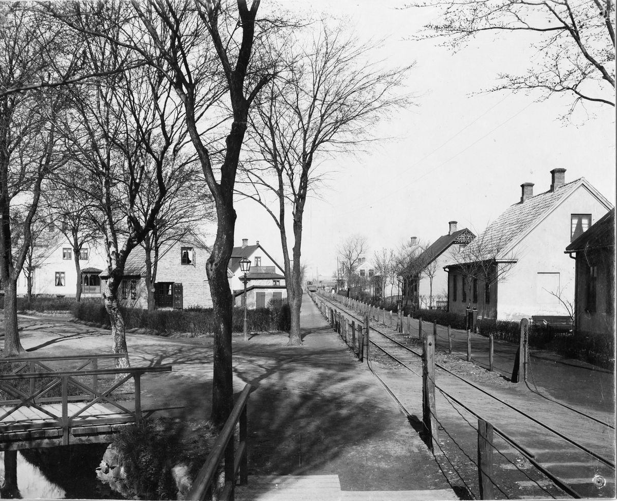 Järnvägen mellan gruvschakten och fabrikerna i Höganäs. Korsningen Storgatan. På båda sidor ses arbetarbostäder. Till vänster gruvkanalen.
