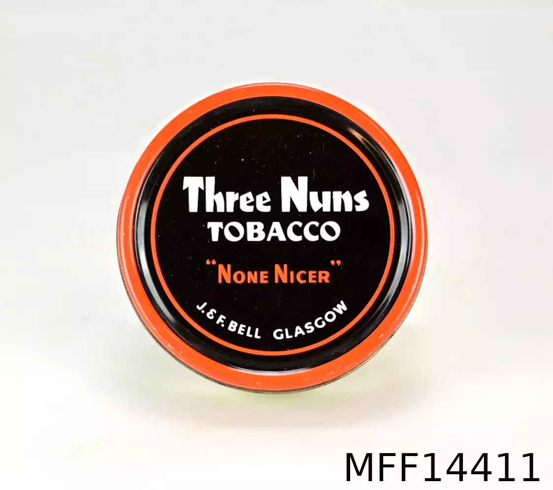 Plåtask. Three Nuns Tobacco "Non Nicer". J. & F. Bell Glasgow. 50 grammes net weight. Orange/svart/vitt lock. Etikett: "Import Riktpris 5:70 kr". Präglat "024".
Anm: Curly cut är en tobak som rullats till stänger och sedan skivats. Rondellernas storlek kan variera mellan en tioörings och en femkronas storlek. Den mest kända tobaken inom denna grupp är Three Nuns, liksom Capstan, en gammal trotjänare. Three nuns licenstillverkas i Danmark. Det är en blandning av Virginia och Perique och den är av medium styrka. De små skivorna ställes lämpligen i pipan. Man får då en fylligare smak än om de gnuggas.
Källa:http://www.svenskapipklubben.se/sv/tobak/artiklar-om-tobak/flake-broken-flake-curly-cut-straight-virginia/