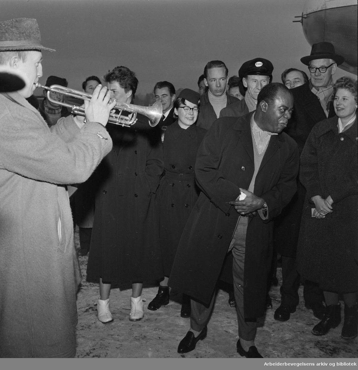 Louis Armstrong ankommer Oslo via Fornebu flyplass 2 februar 1959. Big Chief Jazzband og Eivind Solberg (tv) spiller.