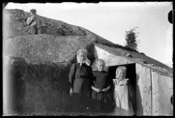 Gruppefoto av barn på et fjell ved et lite skur eller hytte