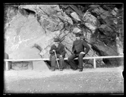 To menn sitter på en benk ved Varbergveien