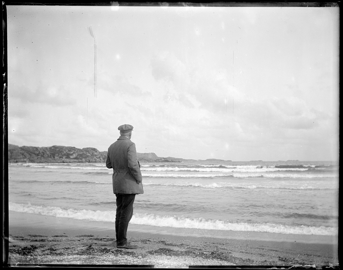 Mann står på Skadbergsanden og ser utover havet