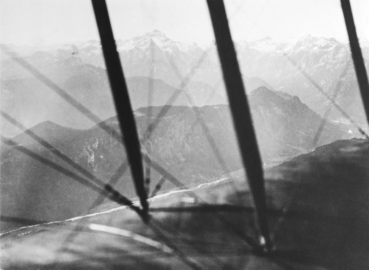 Flygbild av berg i Alperna, 1910-tal. Fotograferat genom flygplansvinge.