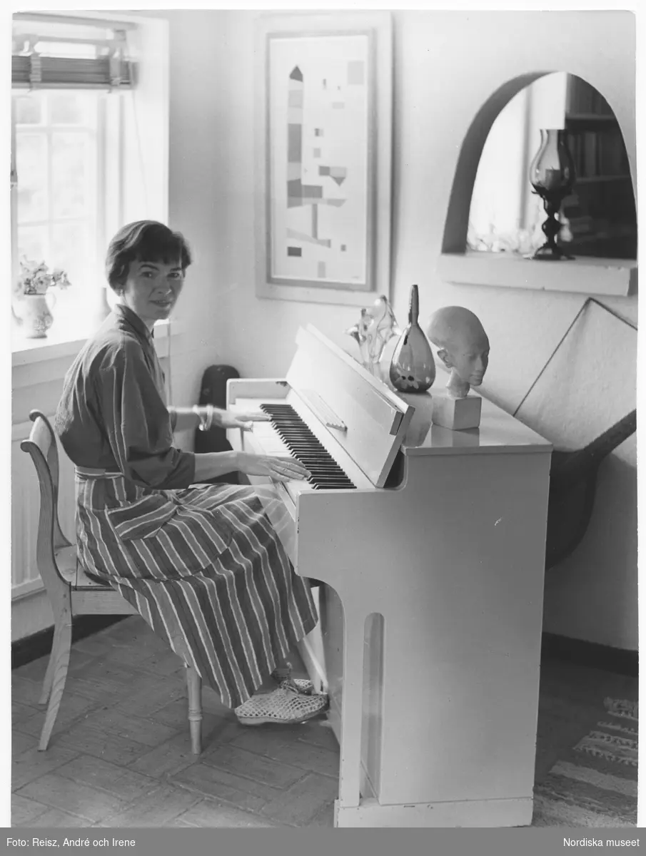 Konstnären Bengt Orups fru, Teddi Orup (född Flygare), vid pianot i deras hem.