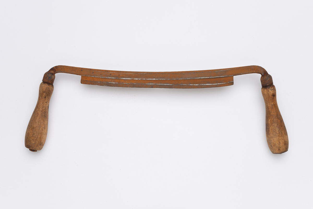 Båndkniv av stål med dreide vinkelrette håndtak av tre. Enkel dreid strekdekor midt på og øverst på håndtak.
