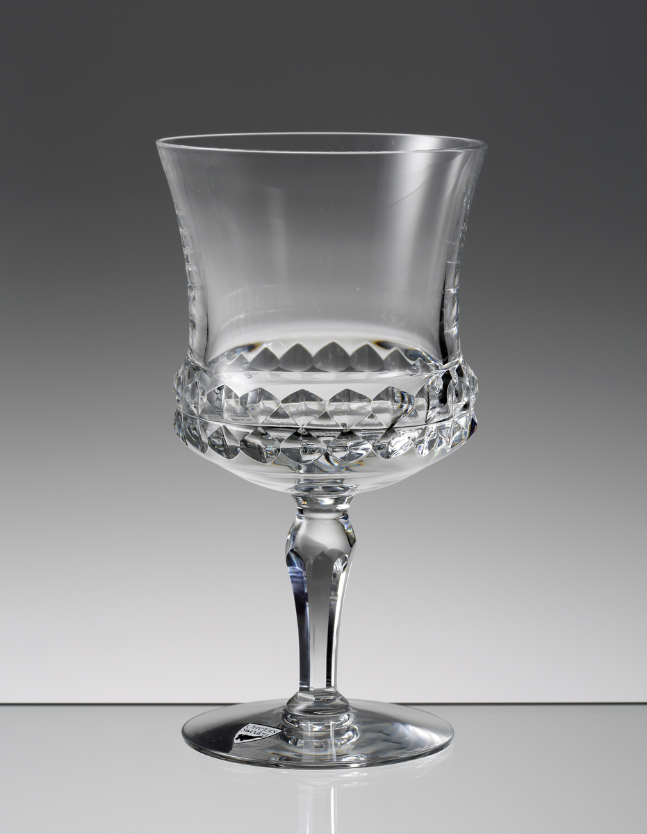 Design: Ingeborg Lundin.
Ölglas. Närmast cylindrisk kupa med diamantslipad dekor runt kupans nedre del. Fasettslipat vulsterben.