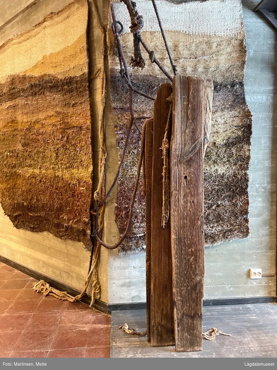 Kunstverket består av to vevde tepper med flere flettede tau som går ut fra dem. Teppene og tauene symboliserer fjell, skog, jord og skogbunn med røtter. I tillegg er en trekonstruksjon knyttet til teppene.