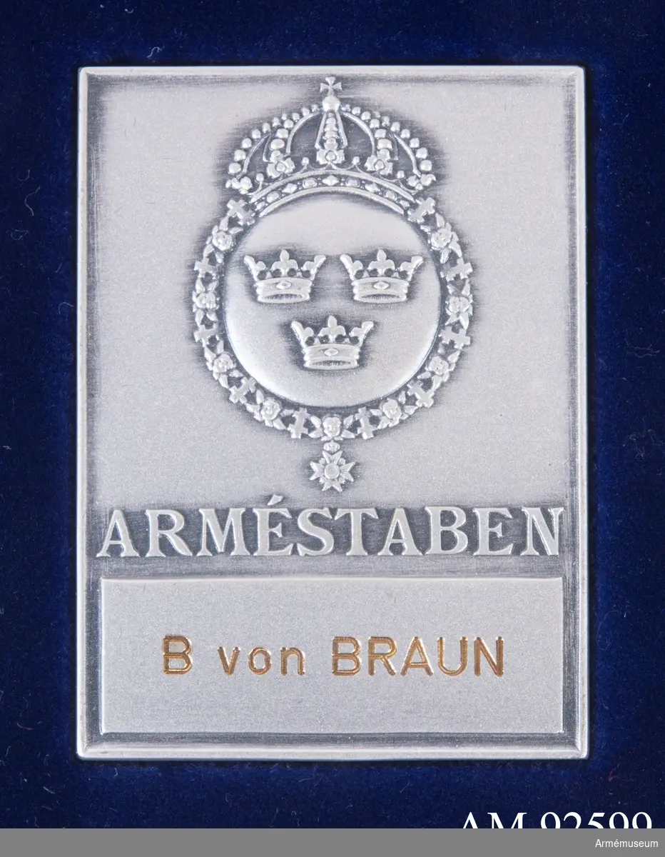 Plakett i silver för Arméstaben med inristat namn "B. von Braun". Plaketten är rektangulär med dekoration av tre kronor inom en krönt ordenskedja. Den ligger i en mörkblå plastask på en bädd av blå sammet.