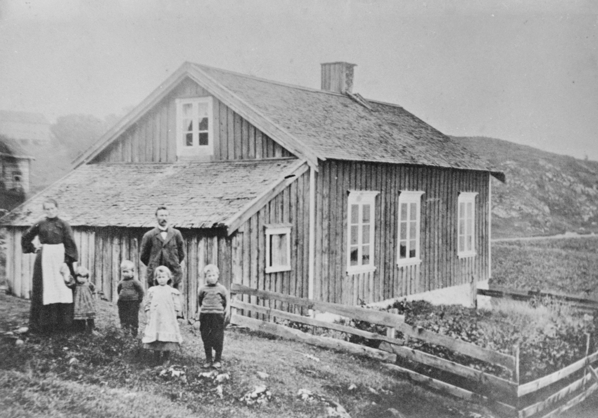 Lærer Ole Larsen Aalmo med familie avbildet utenfor den første skolebygningen på Strand, Hitra.