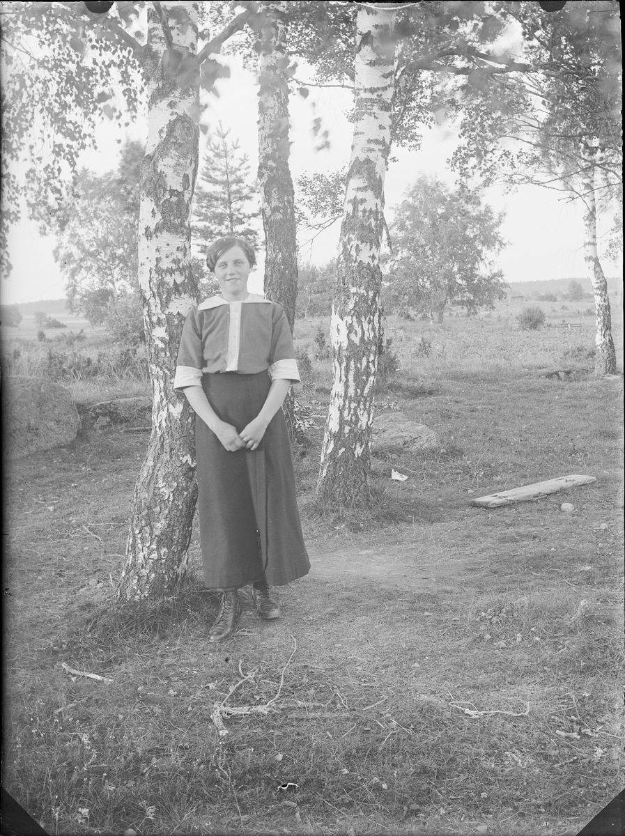 Ung kvinna i trädgård, Alunda, Uppland