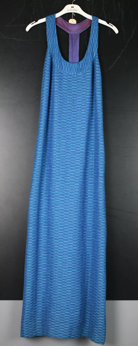 Blå ärmlös klänning med invävda slivertrådar och lila foder, dragkedja i sidan.