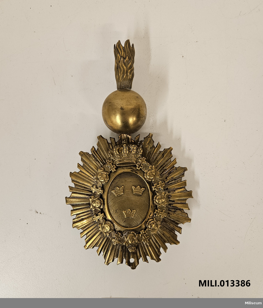 Emblem m/1880 till käppi m/1880, av mässing. Med fastlödd pompong.