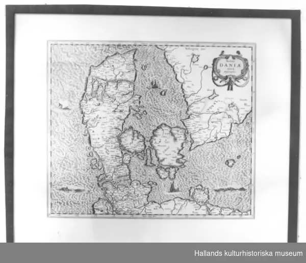 Kopia, nytryck.a) Karta över Danmark. Rektangulär. Akvarellerad. Glasad. Dagermått: bredd: 58,7 cm, höjd: 49,2 cm.b) Ram av trä. Bredd: 2 cm.