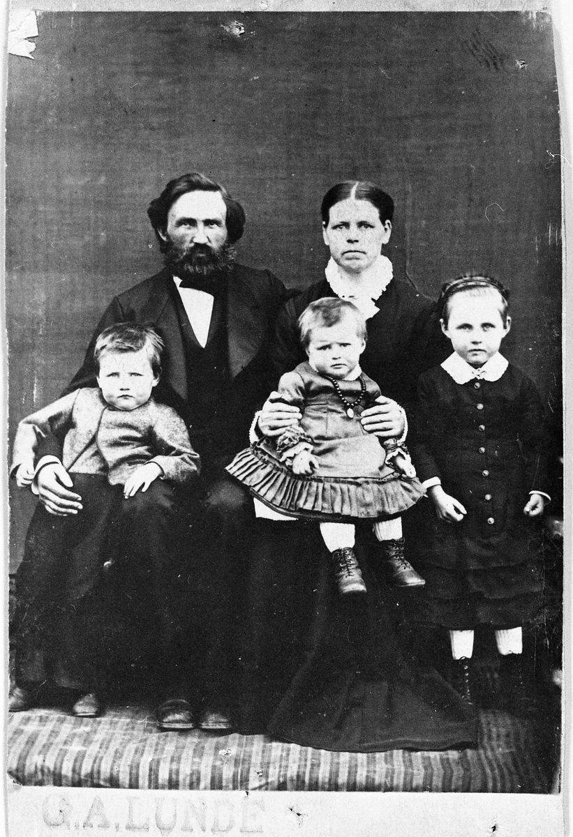 Familieportrett av ekteparet Ole Kristian Thomas Prestrud og hustru Klara født Moldstad, med barna, fra venstre: Johan, Anna (g.m. Johannes A. Nøkleby), og Marthe Kristine født 1876, og gift med Hans A. Gaarder. Året er ca. 1882.