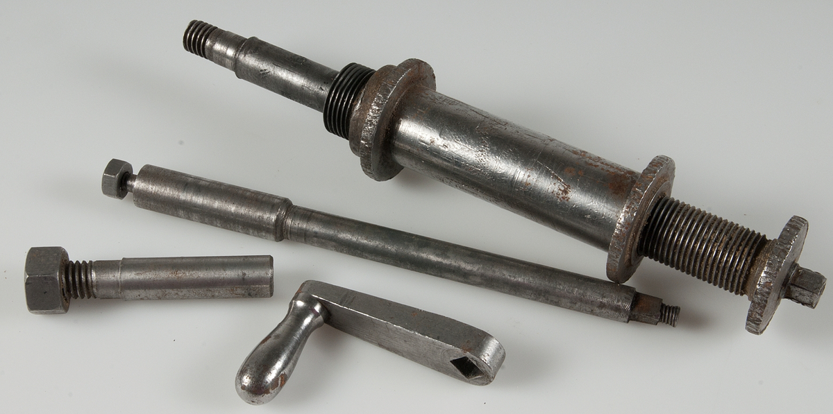 Lösa delar tillhörande verktygslåda. Metall. Drev, muttrar, ringar, vev, 9 bultar, rör i metall mm.