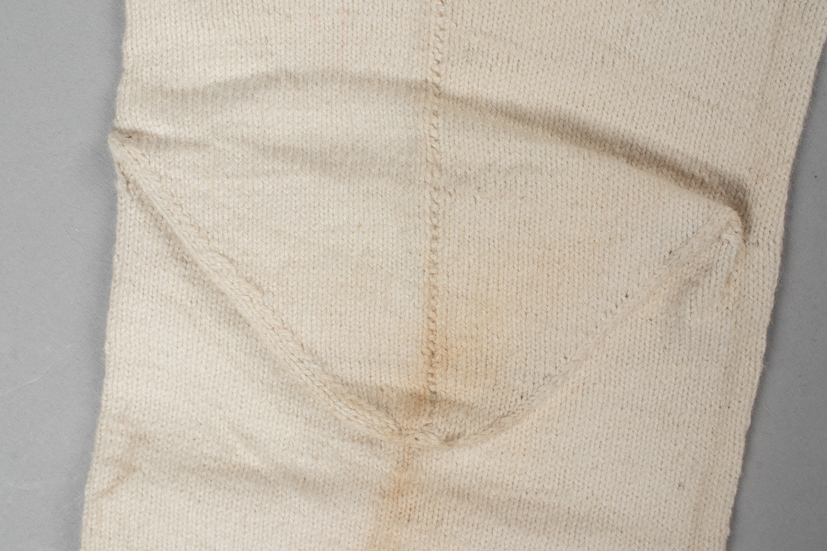 Et par hvite halvstrømper eller knestrømper i glattstrikket bomull med monogrammet AMB brodert i korsting øverst på hver strømpe