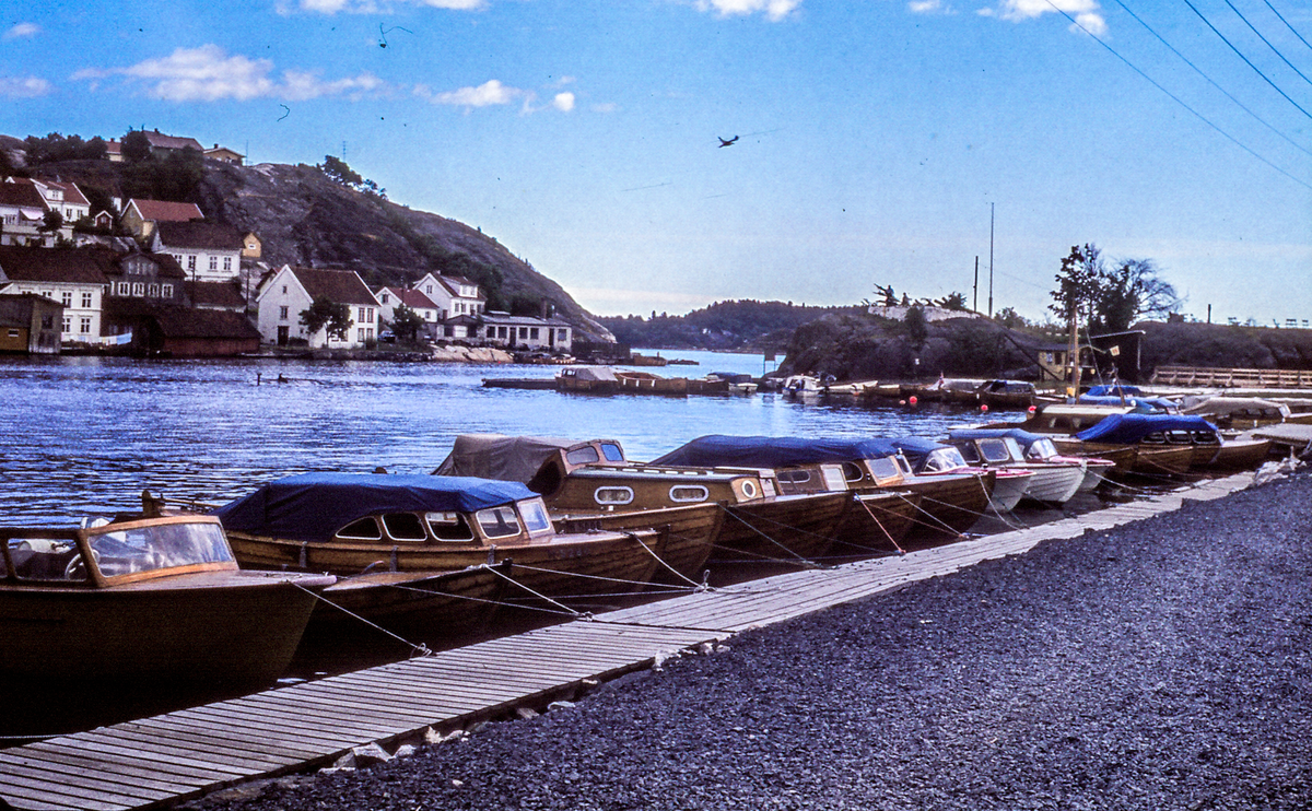 Kogger fortøyet ved moloen ut til Gunnarsholme3n.Fullasted båt ligger ved brygga. Ca. 1970       Et fly.