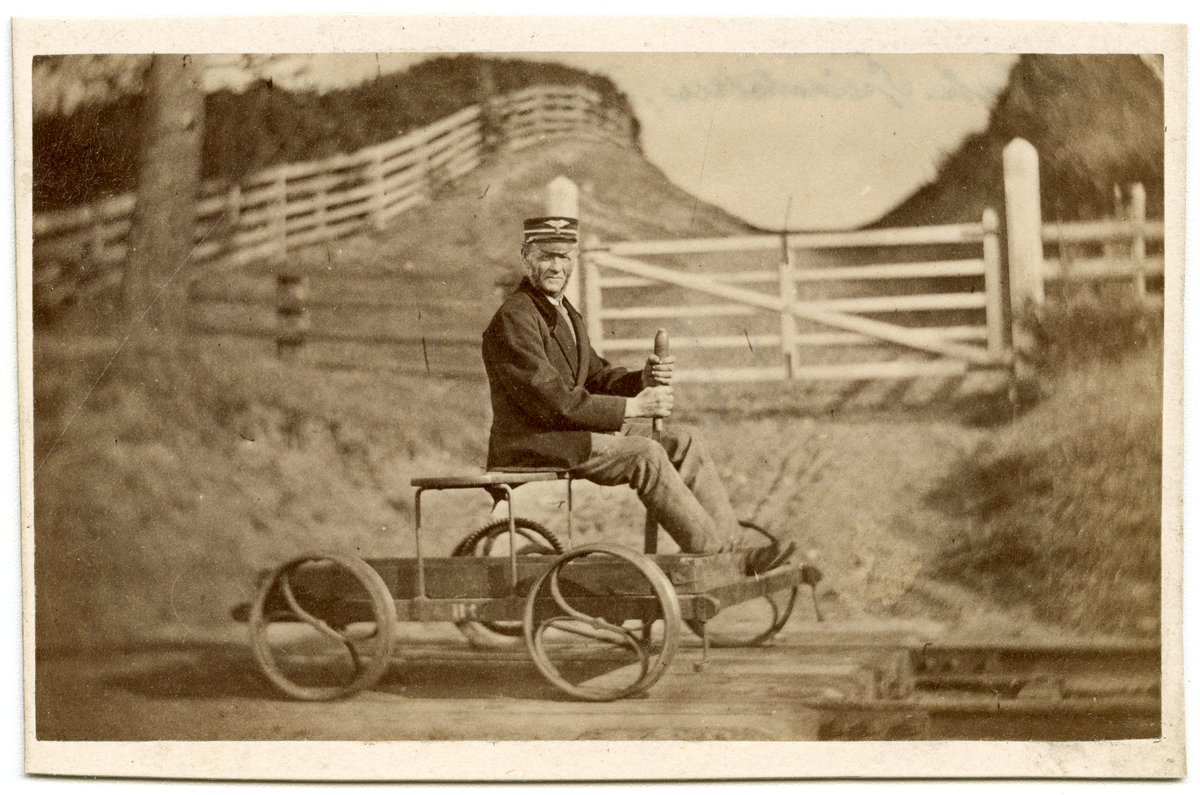 Foto av ukjent mann sittende på pumpedresin, ca. 1875 - 1885