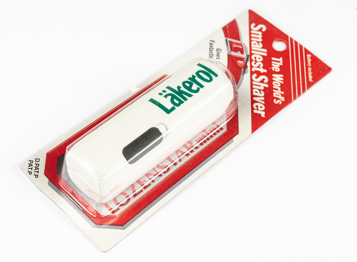 Rakapparat, batteridriven, vit med grön text "Läkerol". I vit och röd plastförpackning.