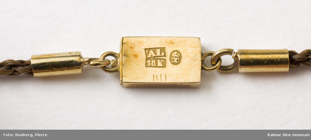 KLM 28102:1. Kedja, i hårarbete. Med fyra hårpärlor och spänne av 18 K guld med initialerna S B. Stämplar: AL, 18K, Karlskrona.