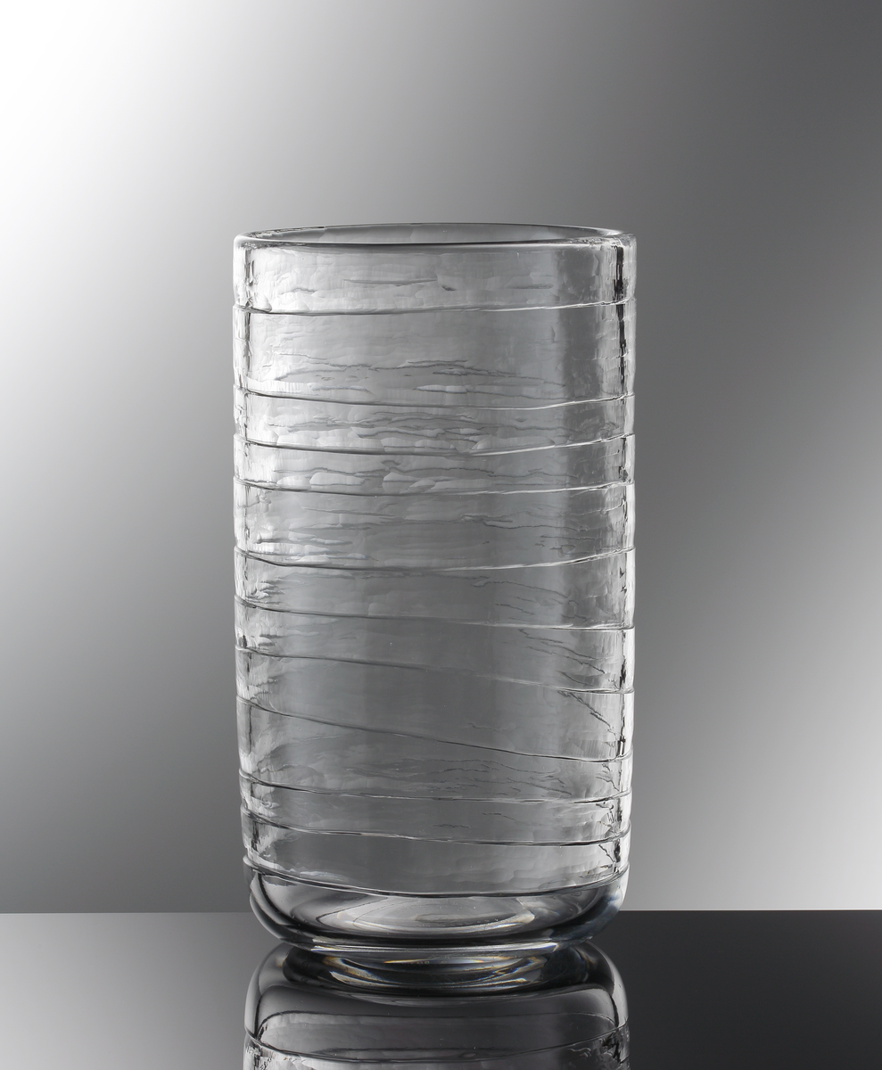 Formgivare: Gunnar Cyrén. Cylindrisk vas med blank reliefgravyr i form av horisontella linjer.
