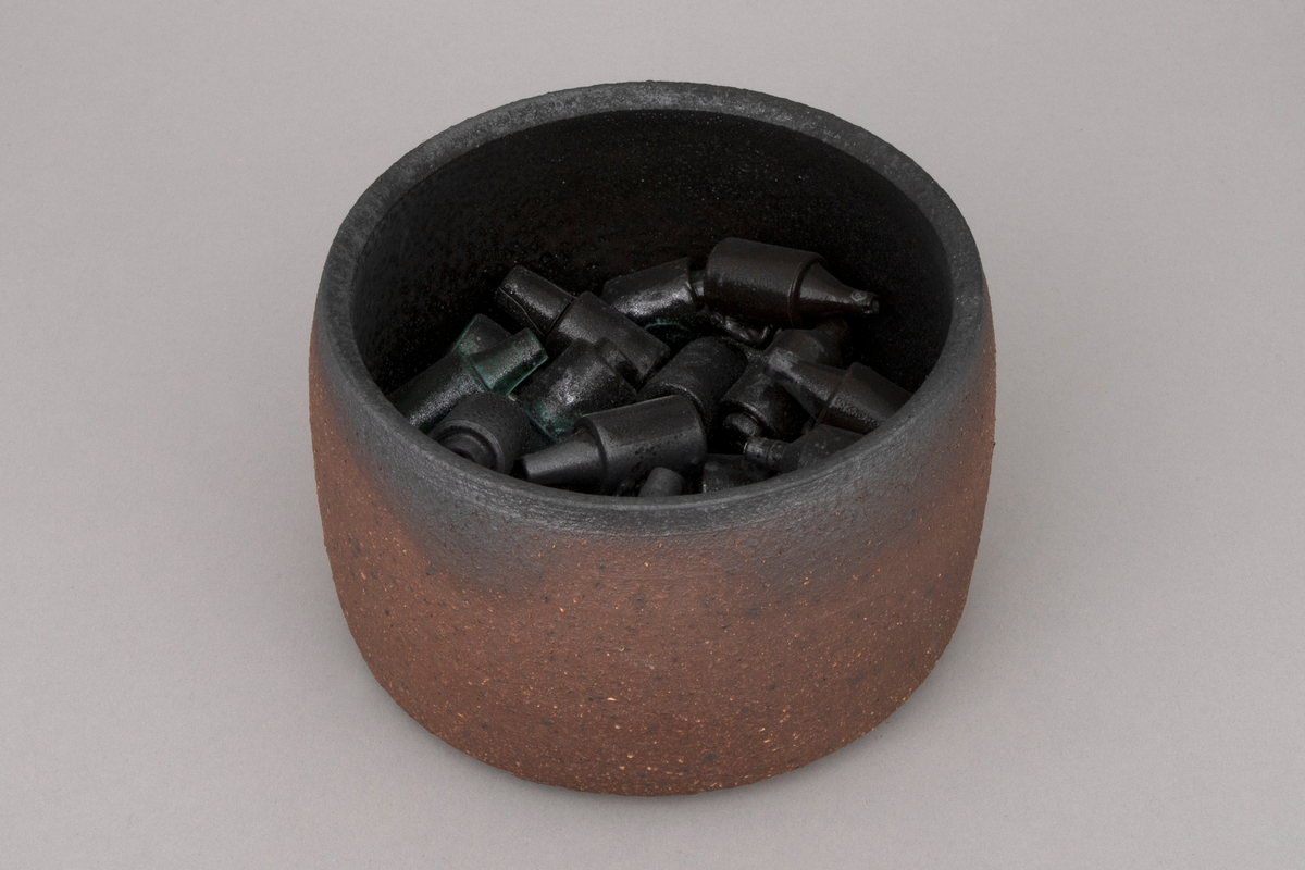 To sylindriske skåler i kobberoksidert steingods med funne sikringer.
