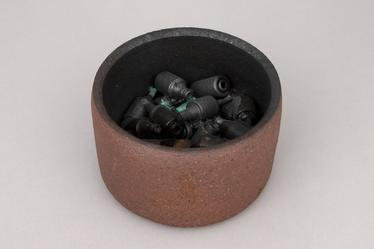 To sylindriske skåler i kobberoksidert steingods med funnene sikringer.
