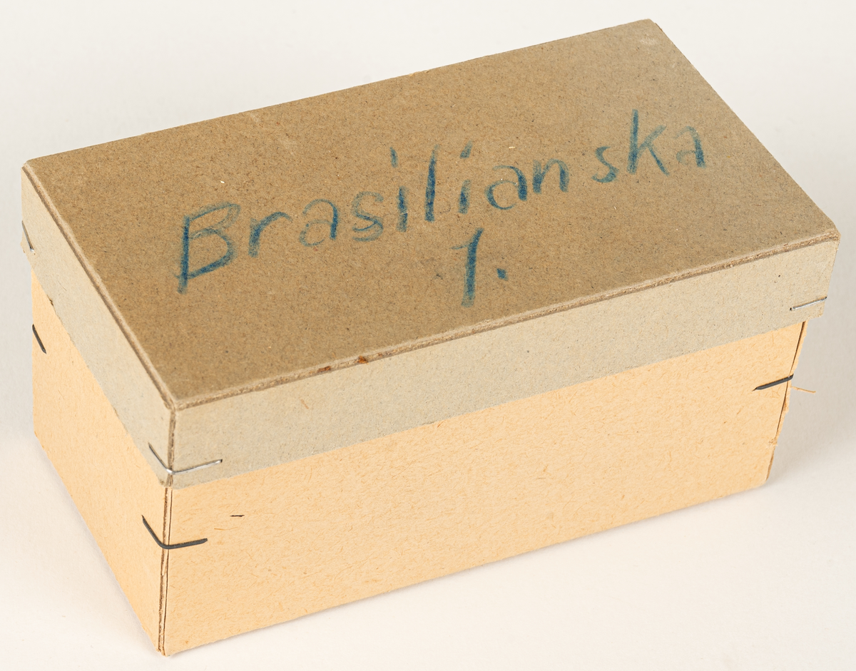 Ask i grå papp, innehållande sex tablettaskar i plåt, gröna Läkerolaskar. På pappasken handskriven text "Brasilianska 1". Läkerolaskar med text på franska. Den ena tablettasken har en klisterlapp med datum 12/8 1949.