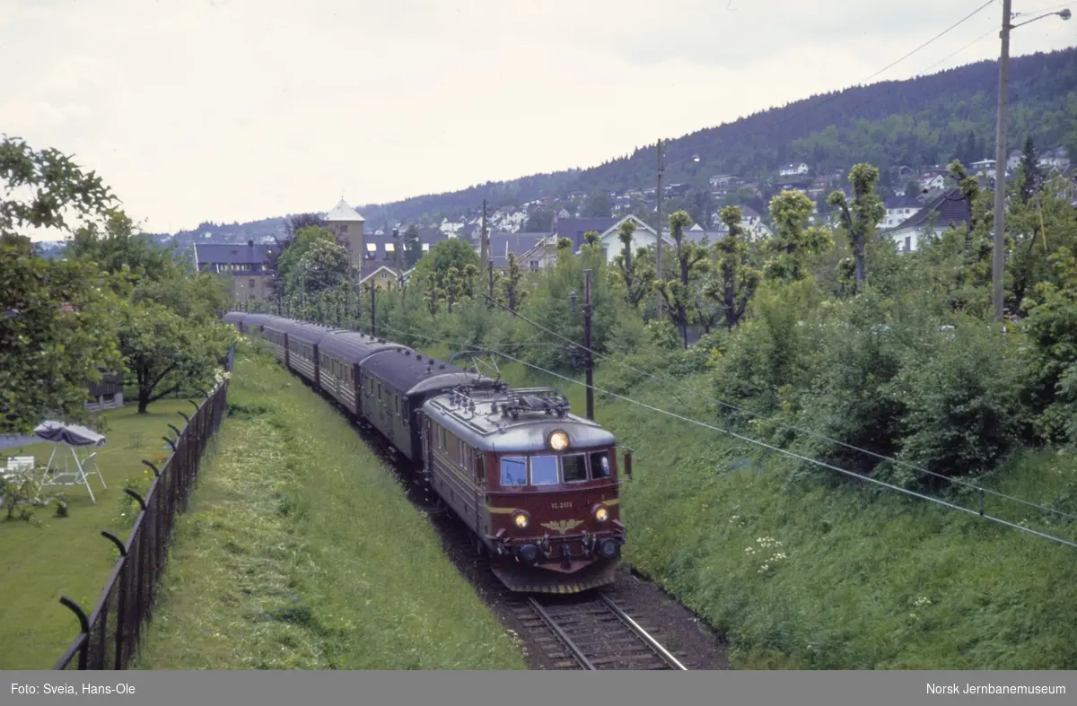 Elektrisk lokomotiv El 11 2111 med persontog fra Skinen N til Oslo, tog 804, mellom Danvik nedlagte holdeplass og Vestfoldbanekrysset i Drammen.