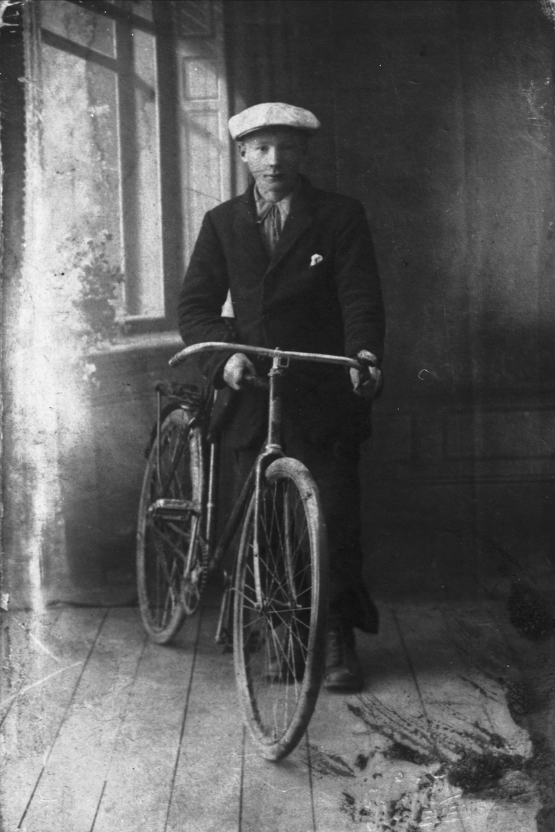 Studioportrett av ung mann fra Skånland med sykkel.