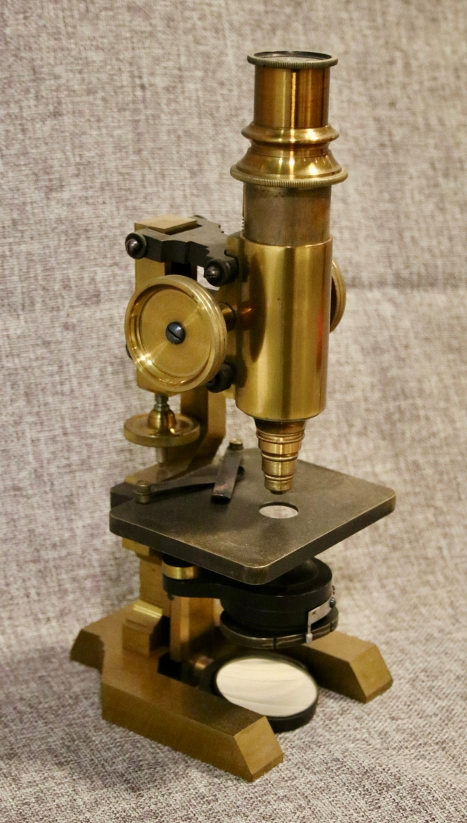 Mikroskop i messing oppbevart i trekasse.