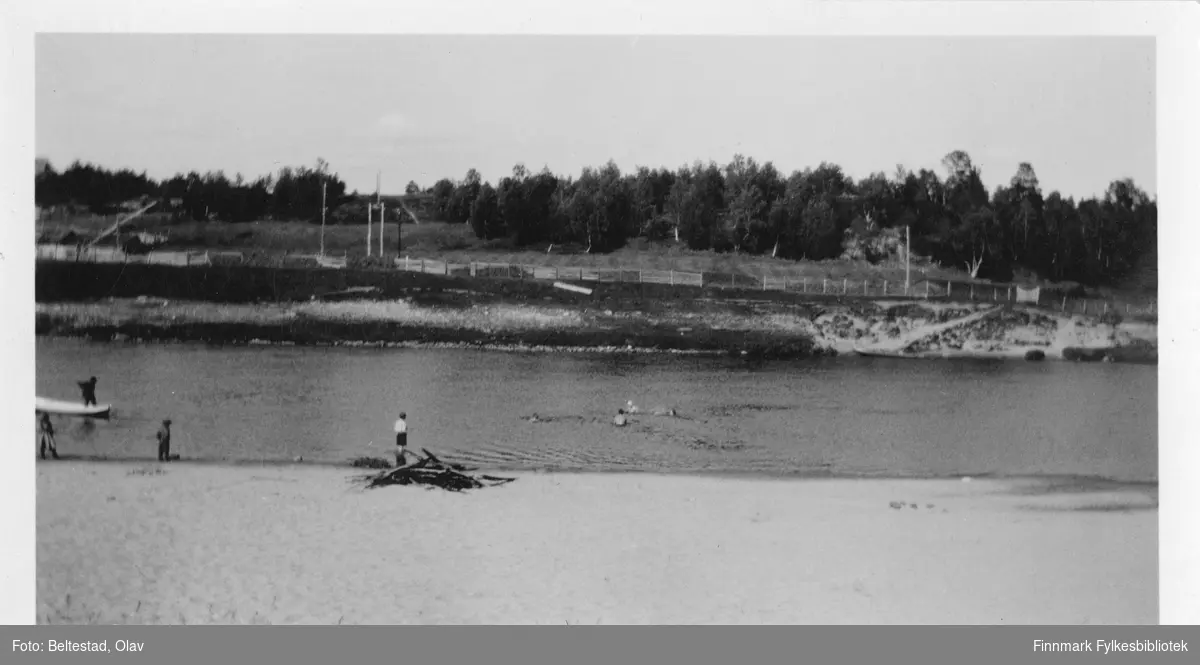 "Karasjokka, 22. juli 1934". Noen svømmer i elva, noen står ved stranden.
