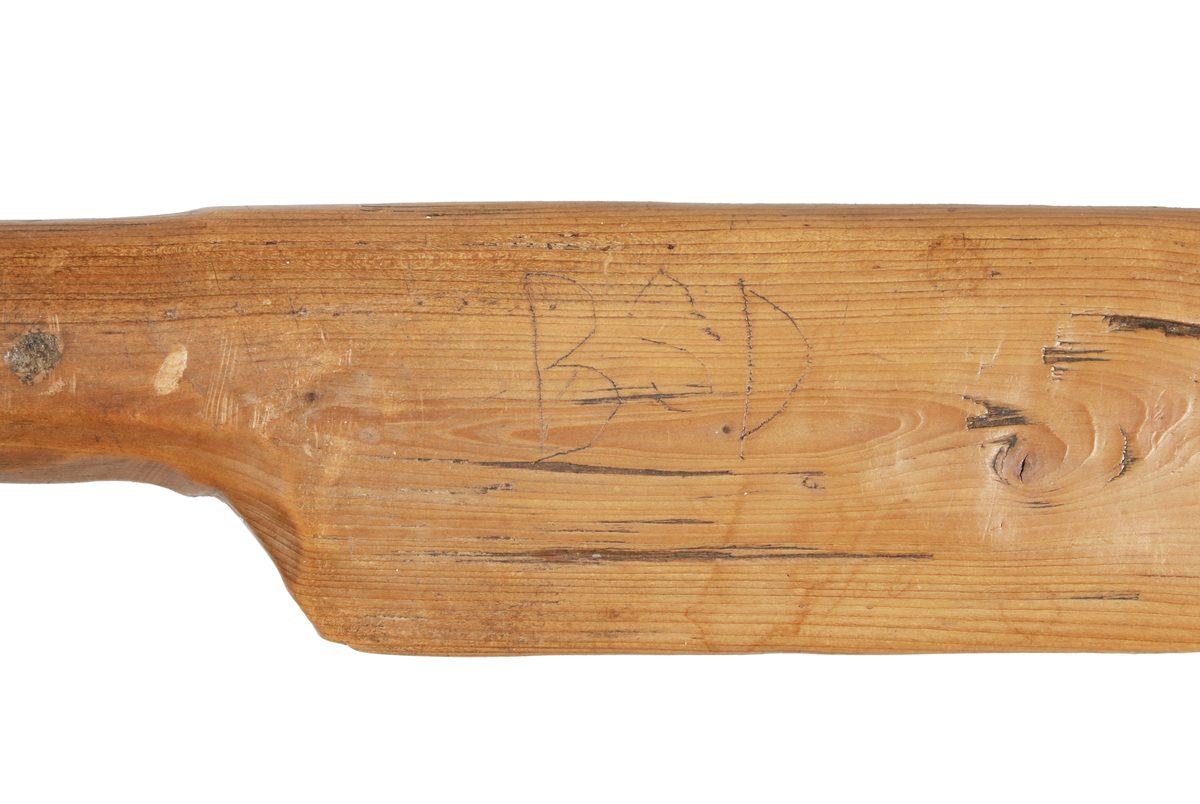 Bandkniv i brunbetsat trä. Tillverkad i ett stycke. På bladet ristat: "BSD". 

Funktion: Bandkniv används för att slå ihop inslagen vid vävning i bandvävstol eller bandgrind.