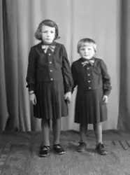 Portrett av 2 jenter i bluse,skjørt og sko.